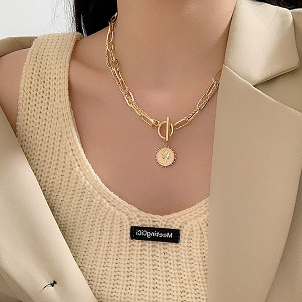 woman wearing a queen coin necklace
